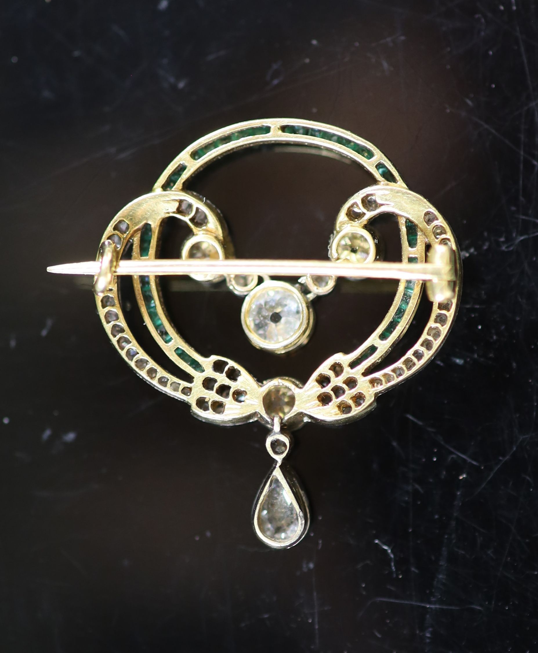 A 1920's gold and platinum, emerald and diamond set open work drop brooch